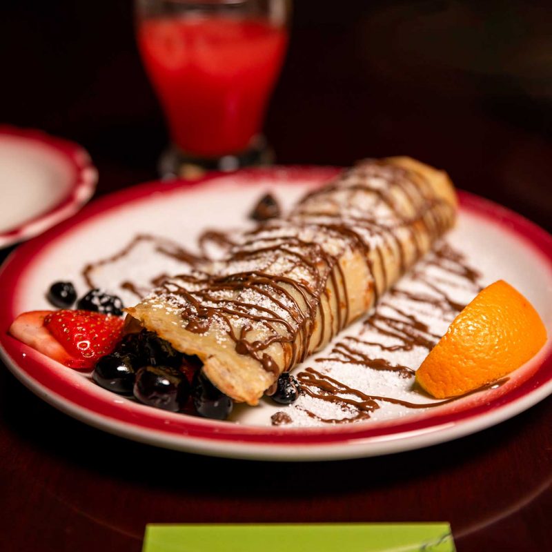 Indulgent chocolate-drizzled sweet crepe with fresh fruit, prepared live by Pantastic Catering.